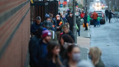 Dezenas de pessoas fazem fila do lado de fora de um supermercado em Londres, nesta terça-feira.