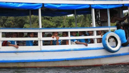 Crianças a caminho da escola, em barco.