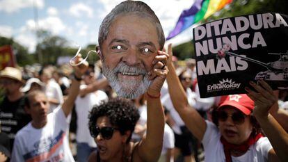 Mulher mostra máscara do ex-presidente Lula durante ato contra golpe de 64.