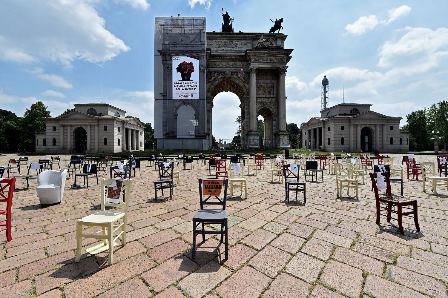 Donos de restaurantes de Milão, na Itália, espalham cadeiras vazias no Arco della Pace representando as vítimas da covid-19, nesta quarta-feira.