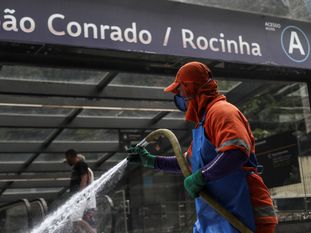 Funcionário limpa estação de metrô e ruas na Rocinha, no Rio.