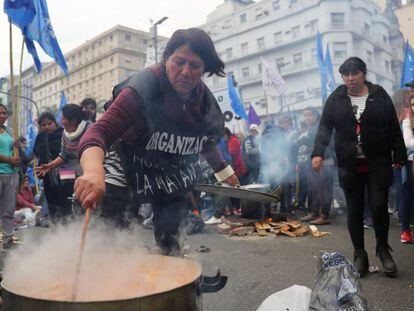 Uma mulher prepara comida em uma manifestação.