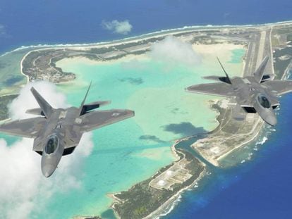 Dois caças F-22 Raptor sobrevoam as três ilhas em U do atol de Wake.
