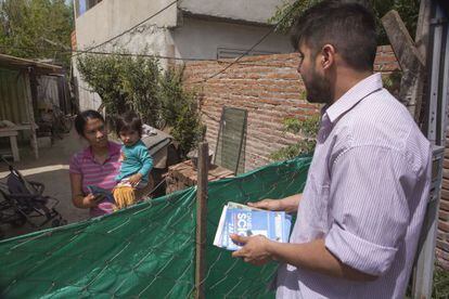 Jovem militante peronista entrega panfleto de Scioli a uma moradora do bairro Obligado de Bella Vista, na Grande Buenos Aires.