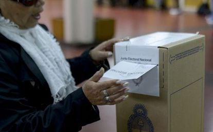 Uma mulher deposita seu voto em Buenos Aires.