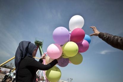 Jovem palestina carrega balões com frases que lembram o Dia Internacional da Mulher, nesta terça-feira, em Gaza.