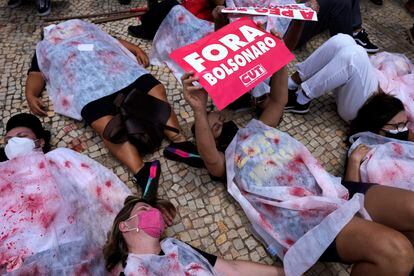 Manifestantes representando os mortos pela covid-19 pedem a saída de Bolsonaro do lado de fora do Palácio do Planalto, em Brasília.