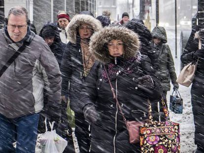 Peatones na rua Wacker Drive em Chicago, nesta segunda-feira. Em vídeo, imagens das nevadas em vários Estados do país.