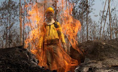 Bombeiro atrás de chamas durante o combate aos incêndios na floresta amazônica, próximo de Porto Velho.