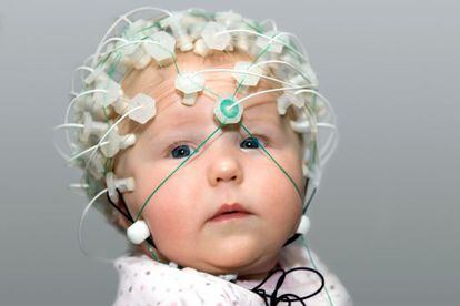 Um bebê de seis meses com um capacete de eletrodos para registrar sua atividade cerebral.