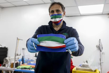 Fabricante mostra máscara de pano feita com as cores da bandeira da Itália, em Roma.