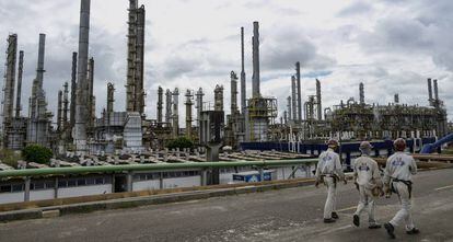 Trabalhadores passeiam diante da indústria petroquímica em Camaçari, no Brasil
