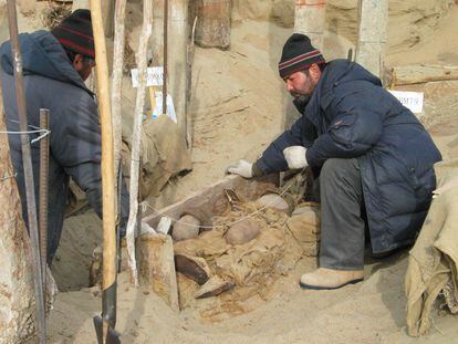 Escavação de uma tumba no cemitério de Xiaohe, no deserto de Taklamakan (China). 