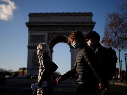 Pedestres caminham pela Champs Elysees, em Paris, com máscaras de proteção contra a covid-19, nesta segunda-feira, 25 de janeiro. Europa cobra transparência das farmacêuticas sobre vacinas.