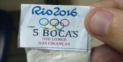 Envelope plástico de cocaína com o símbolo dos Jogos e a advertência.