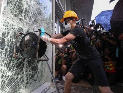 Manifestante tenta quebrar janela do Parlamento em Hong Kong, nesta segunda-feira.