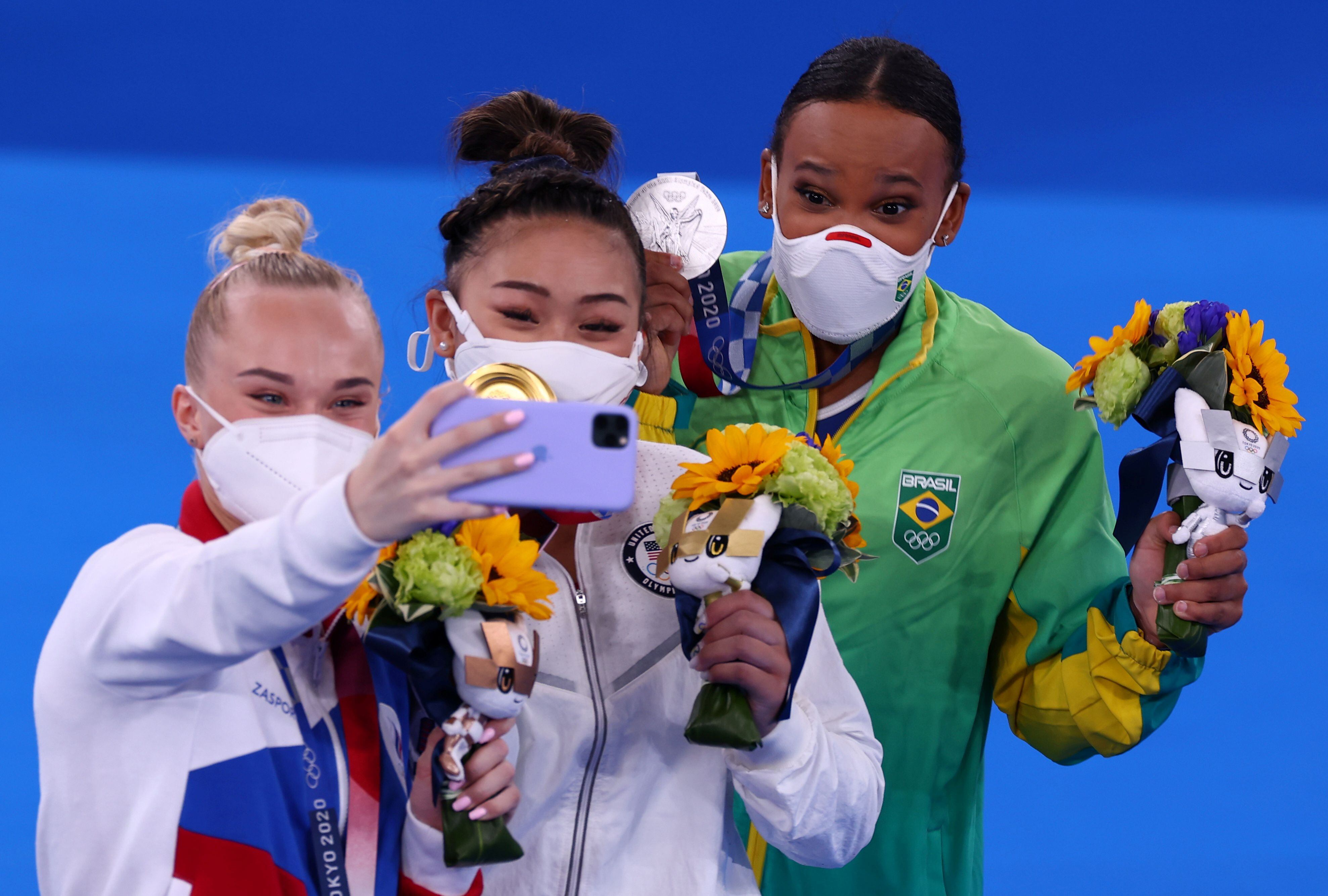 Rebeca Andrade (à direita), com Sunisa Lee (EUA) e Angelina Melnikova (Rússia) no pódio nos Jogos Olímpicos 2020.