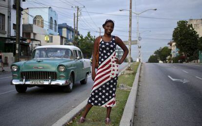 Jovem cubana vestida com a bandeira norte-americana em Havana.