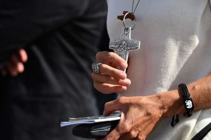 Mulher segura crucifixo durante a oração do Angelus conduzida pelo papa Francisco em 25 de outubro na praça de São Pedro (Vaticano).