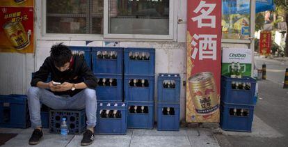 Trabalhador ao lado de caixas de cerveja em Pequim, China, um dos mercados onde a nova empresa poderá enfrentar problemas regulatórios.