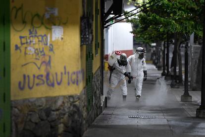 Trabalhadores sanitários desinfetam as ruas de Caracas, na Venezuela.