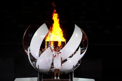 Naomi Osaka segura a tocha olímpica após acender a pira no Estádio Nacional de Tóquio.