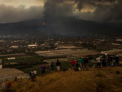 Um grupo de curiosos contempla a erupção do vulcão em La Laguna, na terça-feira.