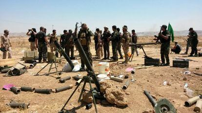 Soldados das forças curdas de Peshmerga e voluntários xiitas tomam posições em Amerly, no noroeste de Bagdá, em 7 de agosto.