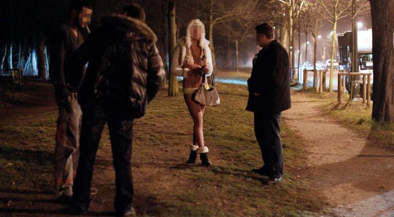 Dois agentes interrogam prostituta e cliente durante operação policial