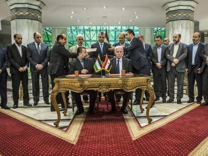 O representante do Fatah, Azzam al-Ahmad (na mesa, à direita) e o líder do Hamas, Salah al-Aruri (à esquerda), assinam a reconciliação no Cairo, na quinta-feira.