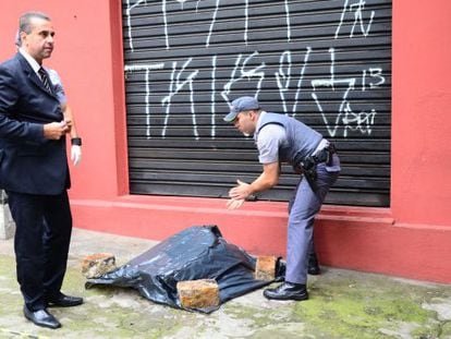 Policiais ao lado de partes de um corpo achado em São Paulo.