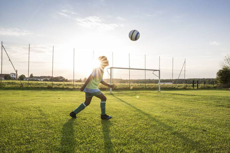 Uma criança joga com sua bola.