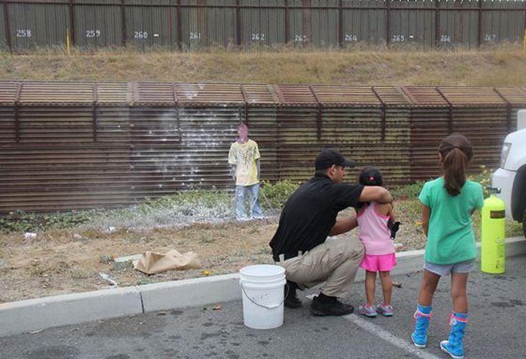 Duas crianças disparam pintura numa silhueta em San Ysidro (EUA) em 2013.