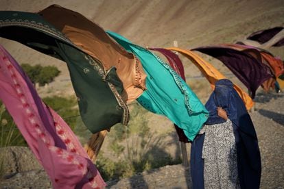 Uma mulher escolhe tecidos para comprar numa banca na estrada que leva de Jalalabad a Cabul. 