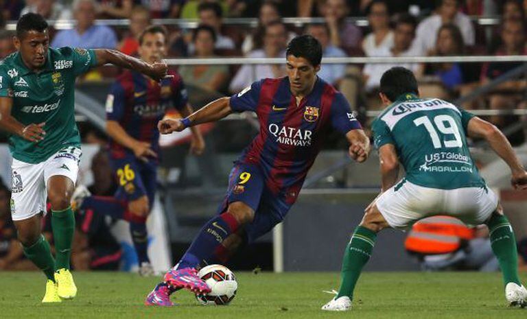 Luis Suárez dribla dois rivais.