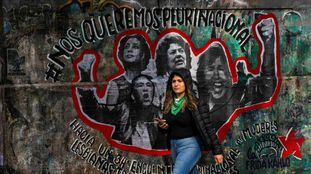 Jovem passa em frente a um grafite alusivo ao XXXIV Encontro Nacional de Mulheres da Argentina, ocorrido em outubro.