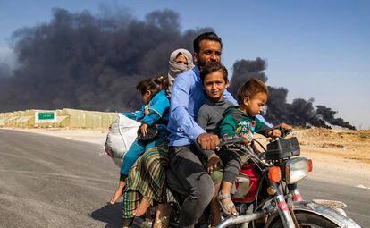 Uma família de deslocados abandona a cidade curda de Ras al Ain na quarta-feira.