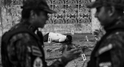 Policiais mexicanos juntos a um cadáver em Acapulco, a cidade com uma das maiores taxas de homicídios.