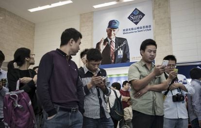 Vários clientes revisam seus celulares em um supermercado de Tianjin (China), em 28 de setembro.