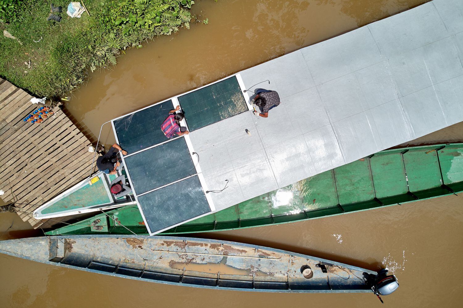 Uma equipe de técnicos indígenas instala os painéis solares no teto do novo barco, no rio Capahuari. 