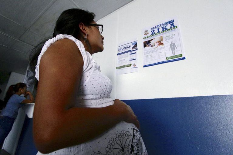 Mulher grávida lê anuncio sobre a Zika