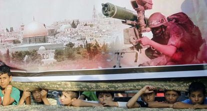 Garotos em Rafah debaixo de um cartaz do Hamas.