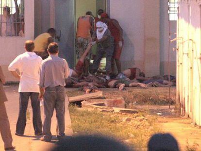 Detentos retiram corpos de presídio durante rebelião de 2008.