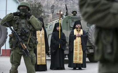 Sacerdotes ortodoxos rezam perto de soldados russos na Balaclava (Crimeia).