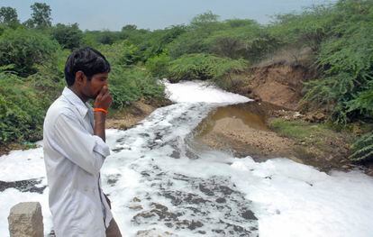 Um homem tampa o nariz em frente ao rio Isakavagu, destino dos dejetos das fábricas de antibióticos de Patancheru, um polo industrial próximo a Hyderabad, na Índia, em uma imagem de 2008. 