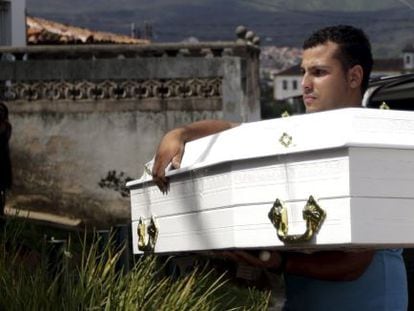 Homem carrega caixão de Emanuele, 5, vítima da tragédia.