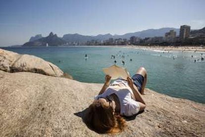 O estudante Victor Caplin lê um livro nas pedras do Arpoador, na praia de Ipanema (Rio).