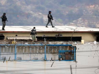 O corpo de um preso aparece rodeado de policiais no teto do Presídio do Litoral em Guayaquil (Equador), na manhã seguinte ao início dos distúrbios, em 13 de novembro de 2021.
