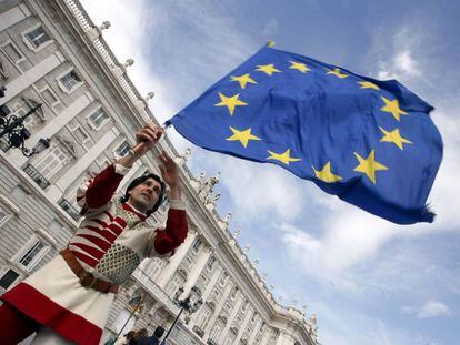 Um membro do grupo italiano "Sbandieratori dei Siena" enquanto sustenta uma bandeira da União Europeia  em frente ao Palácio Real em Madri.