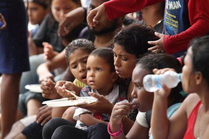 Grupo de crianças venezuelanas come depois de passar dois dias no mar, em Trinidad e Tobago, em 24 de novembro.